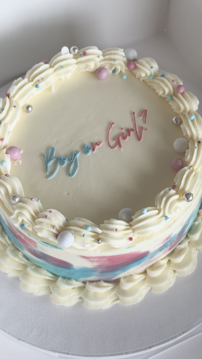 Gender reveal cake with pink and blue watercolour sides, pearls and “Boy or Girl?”